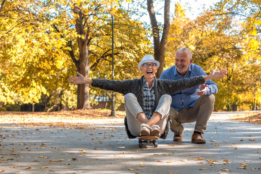 An elderly couple with a woman sitting on skate in the park